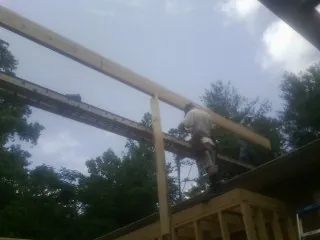 Carpenter setting a ridge beam over a new addition frame — Ice Dam Removal by Roofing Brothers in Cedar Knolls