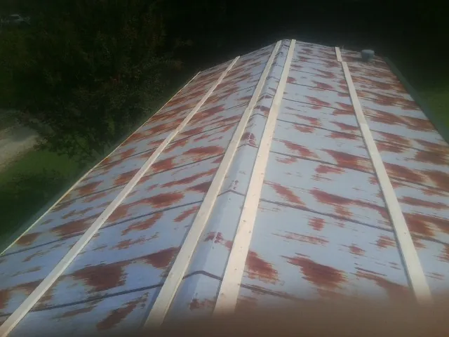 Rusted metal roof panels with new wood purlins before replacement — Storm Damage Roof Repair in Cedar Knolls by Roofing Brothers